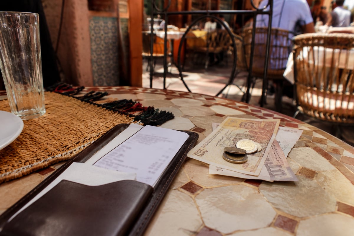 Moroccan dirham notes beside a restaurant bill, no clear faces