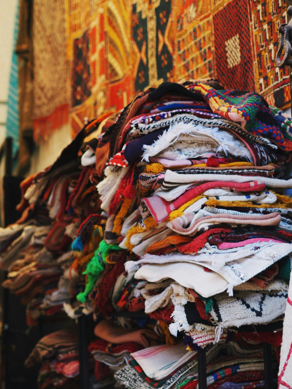A Moroccan carpet shop interior with stacked and hanging rugs, no faces