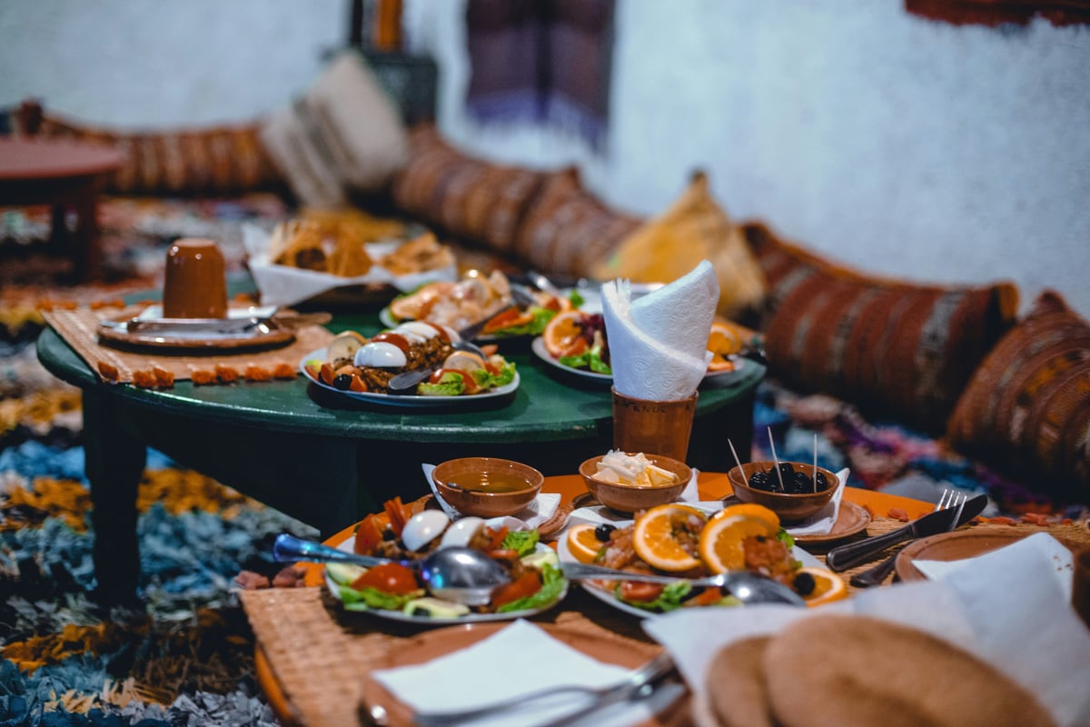 A festive iftar table with Moroccan food and dates at sunset, no faces