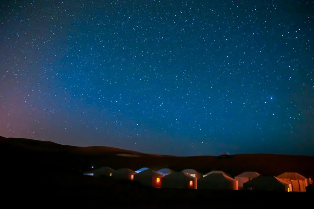 A desert camp at night under stars, or Fez medina rooftops, no faces