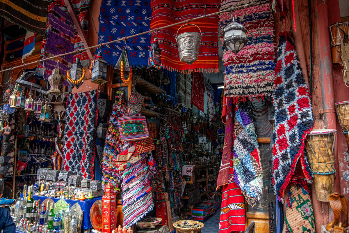 A colorful Moroccan souk stall with lanterns, textiles and goods, no clear faces