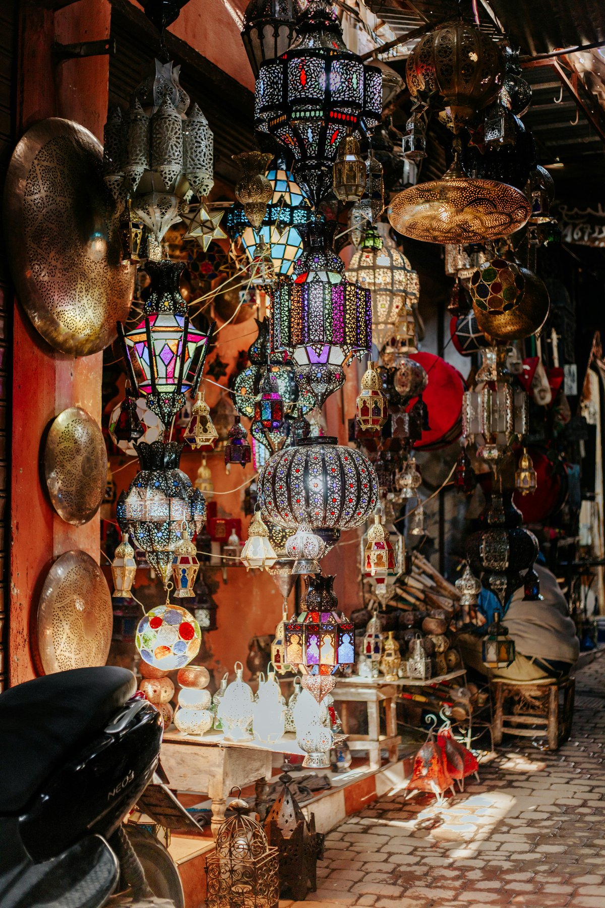 Moroccan lamps, ceramics and crafts displayed in a souk, no faces