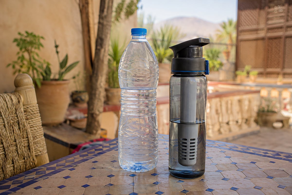 Bottled water and a reusable filter bottle on a table, no faces