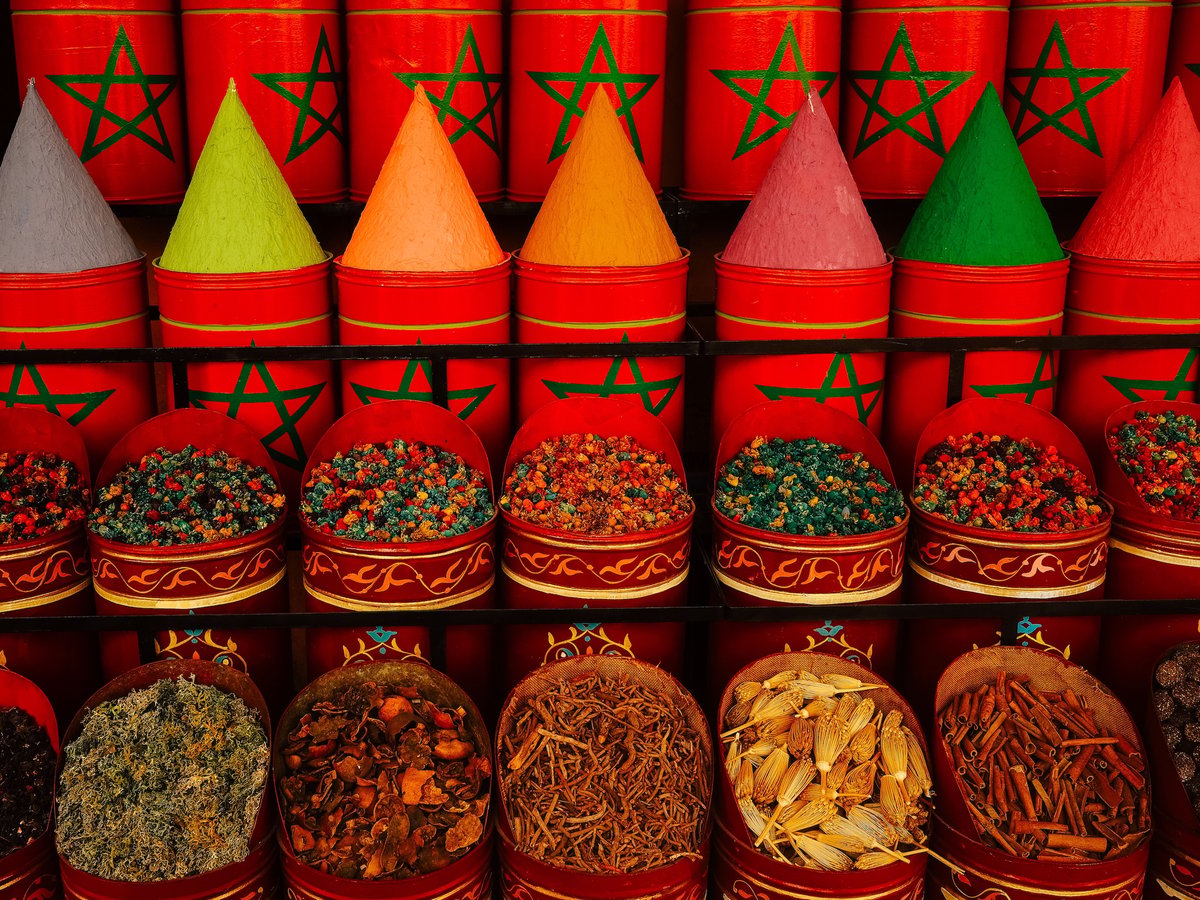 Colorful Moroccan spices and argan oil bottles at a market, no faces