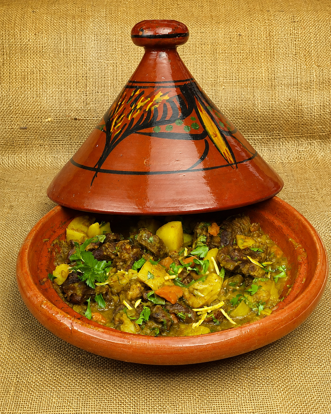 A traditional tagine pot open to show the stew inside, no faces