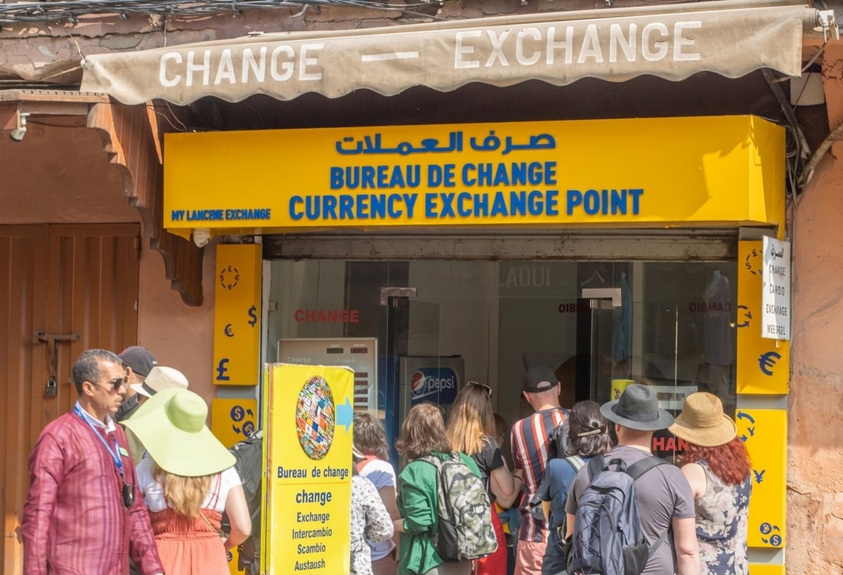 A licensed exchange bureau window in a Moroccan city with posted rate board, no people