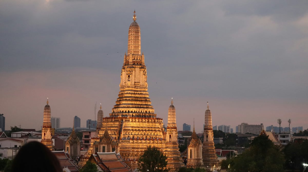 Bangkok's Grand Palace or Wat Arun glowing, with the city beyond