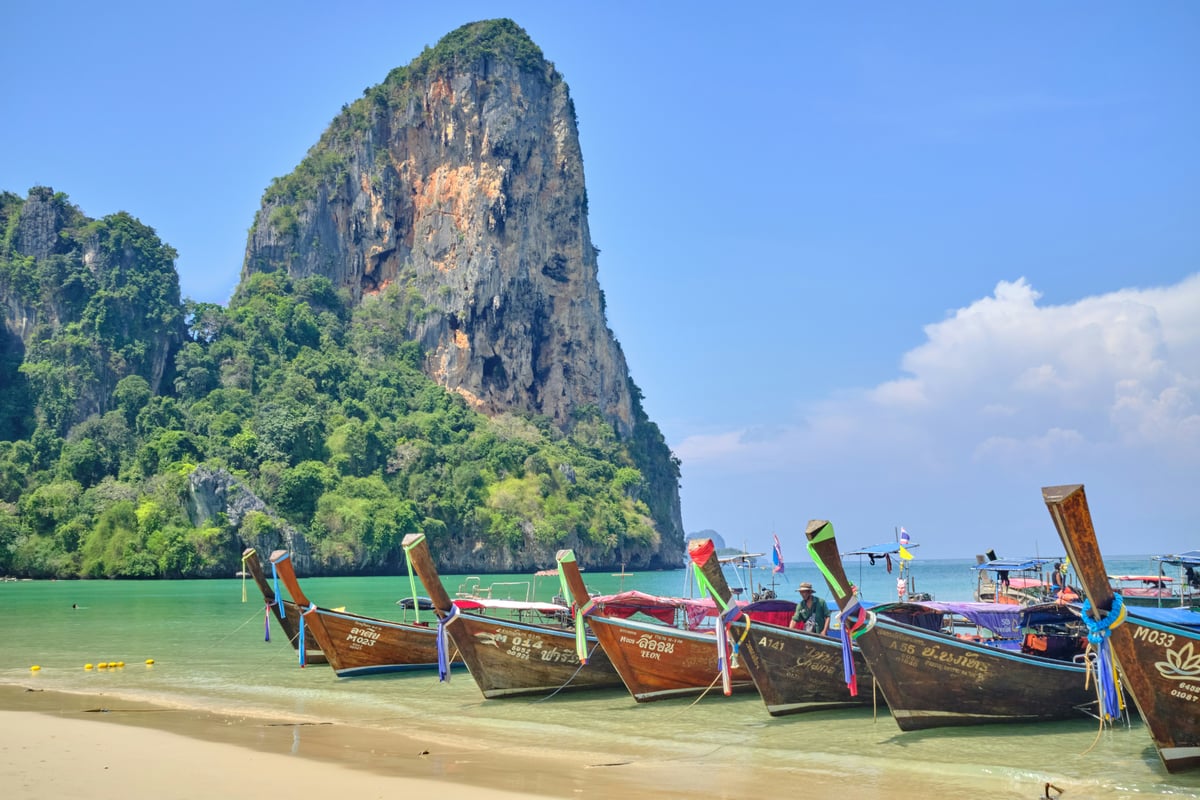 A longtail boat anchored off a limestone karst in the Andaman Sea
