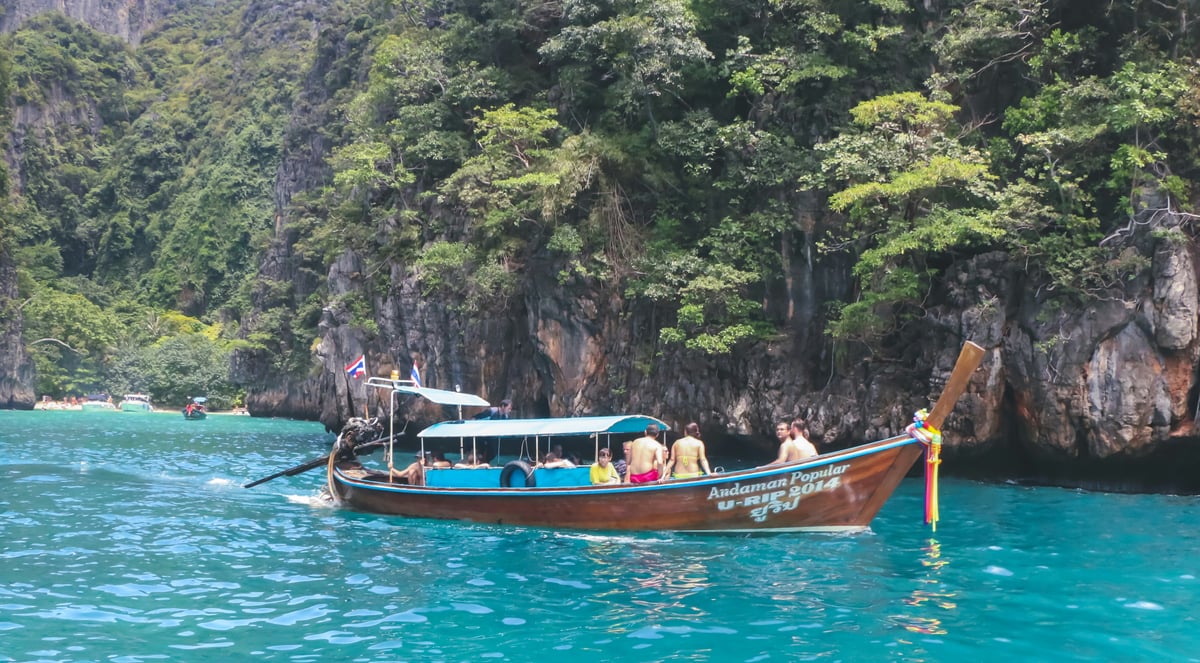 A longtail boat heading toward a Thai island, or a ferry on turquoise water
