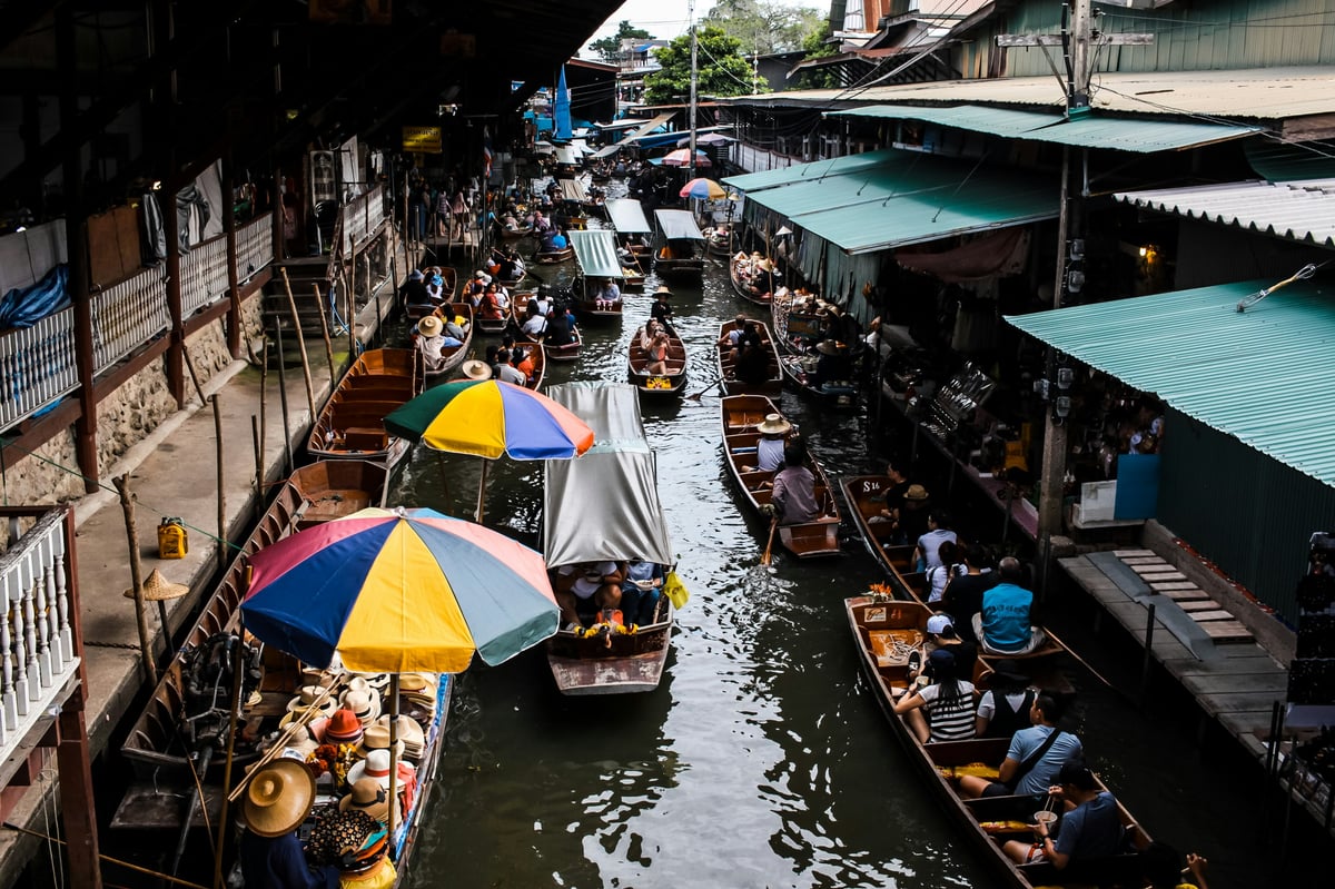 A floating market with vendors in boats selling produce