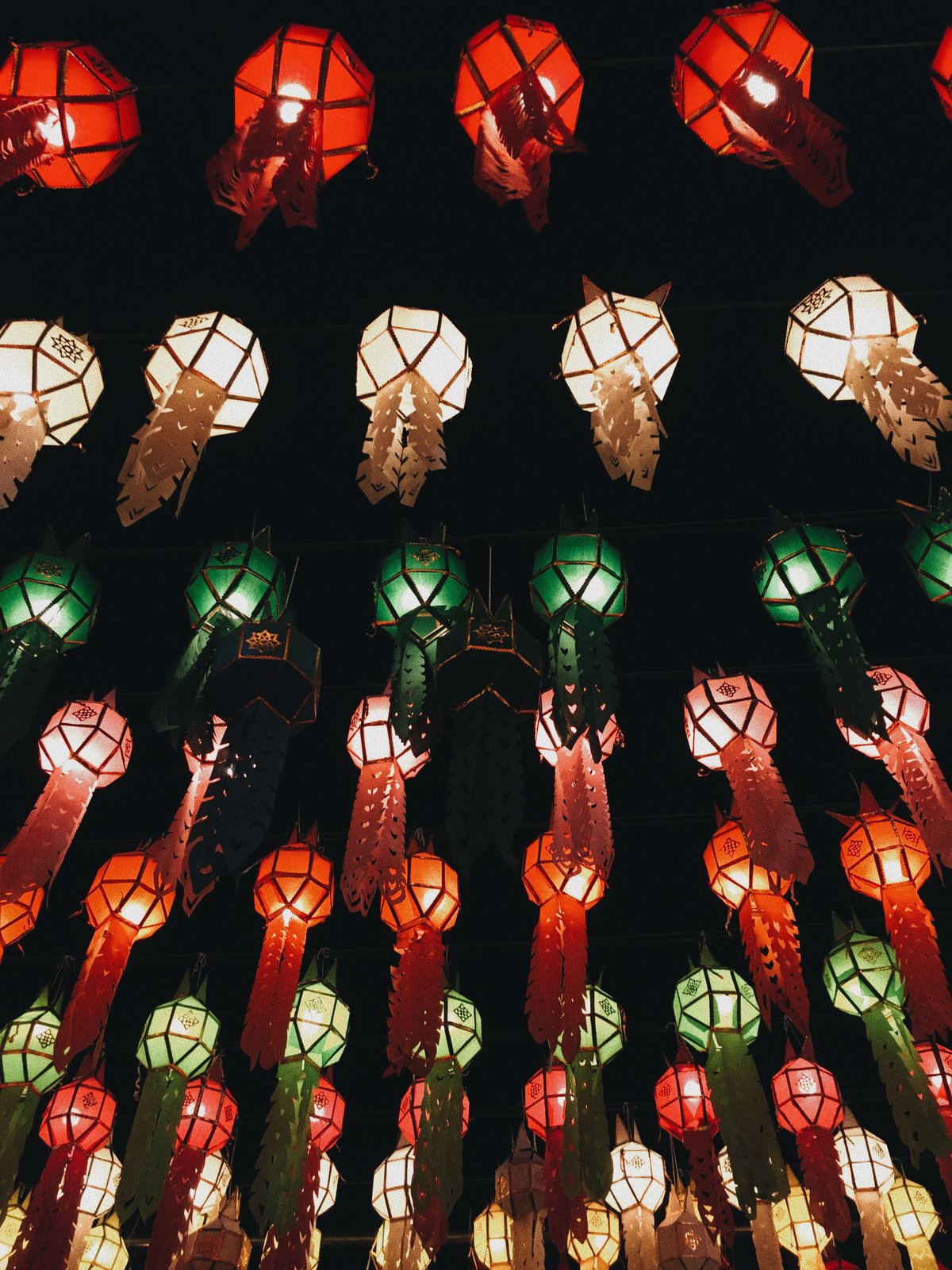 Sky lanterns rising into the night during Yi Peng in Chiang Mai