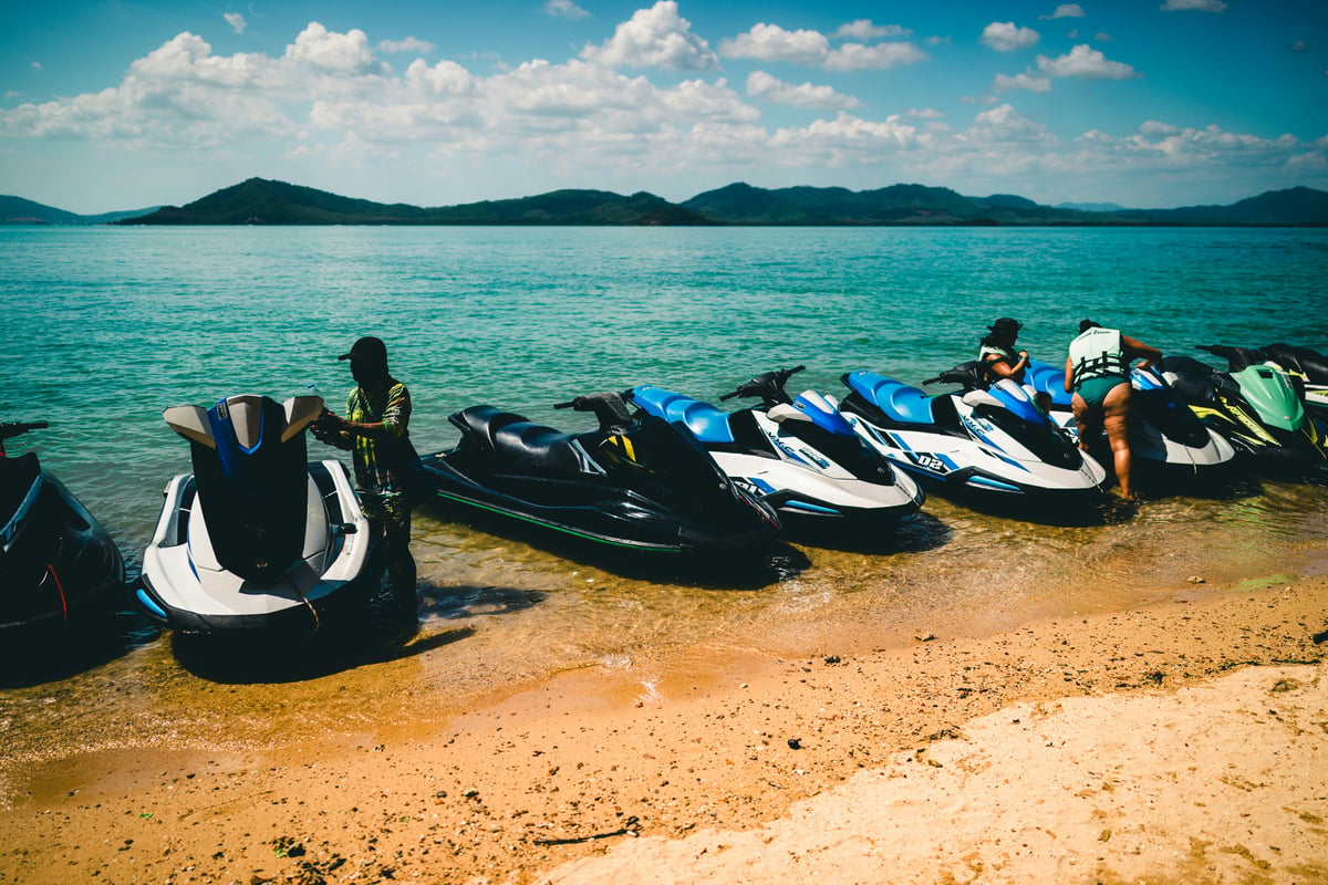 Jet-skis or scooters lined up for rent on a Thai beach