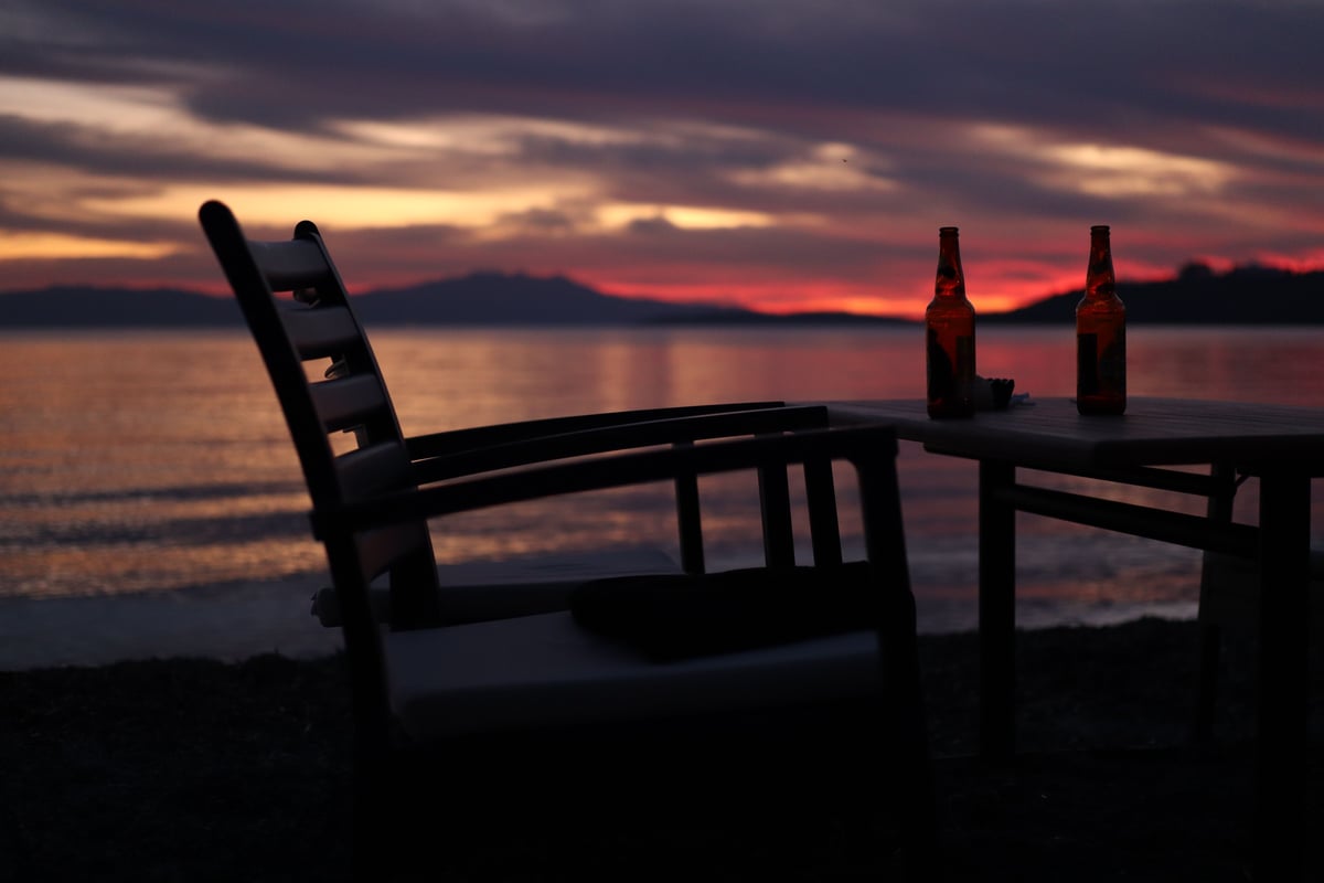Cold bottles of Thai beer on a beachside table at sunset
