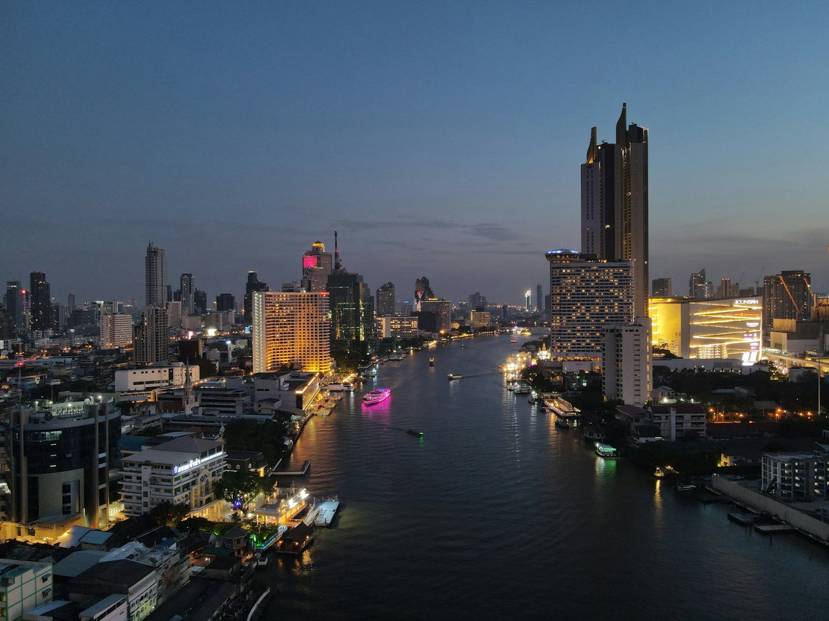 A Chao Phraya river express boat passing a temple