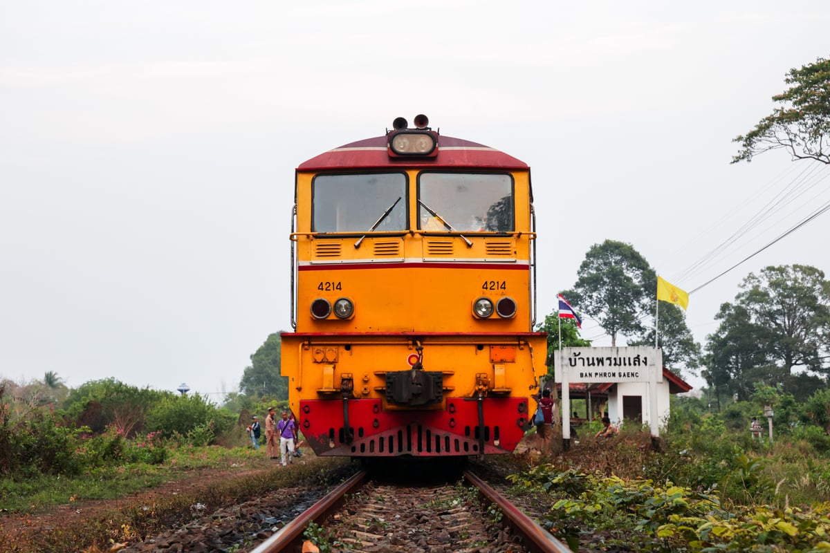 A Thai train winding through green countryside