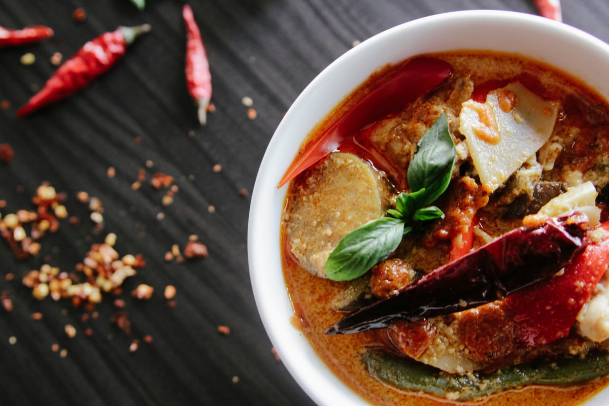 Red and green Thai chilies with a colorful Thai dish