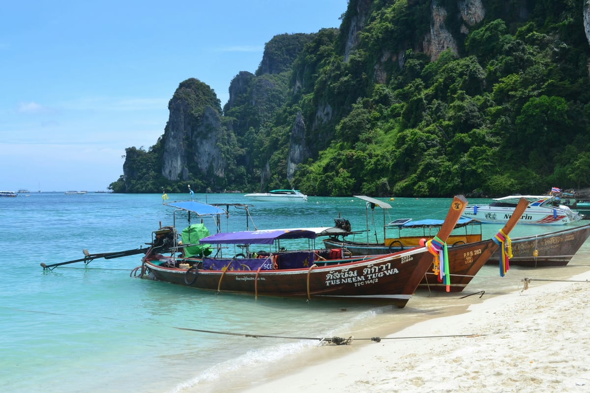 A quiet Thai island beach with longtail boats
