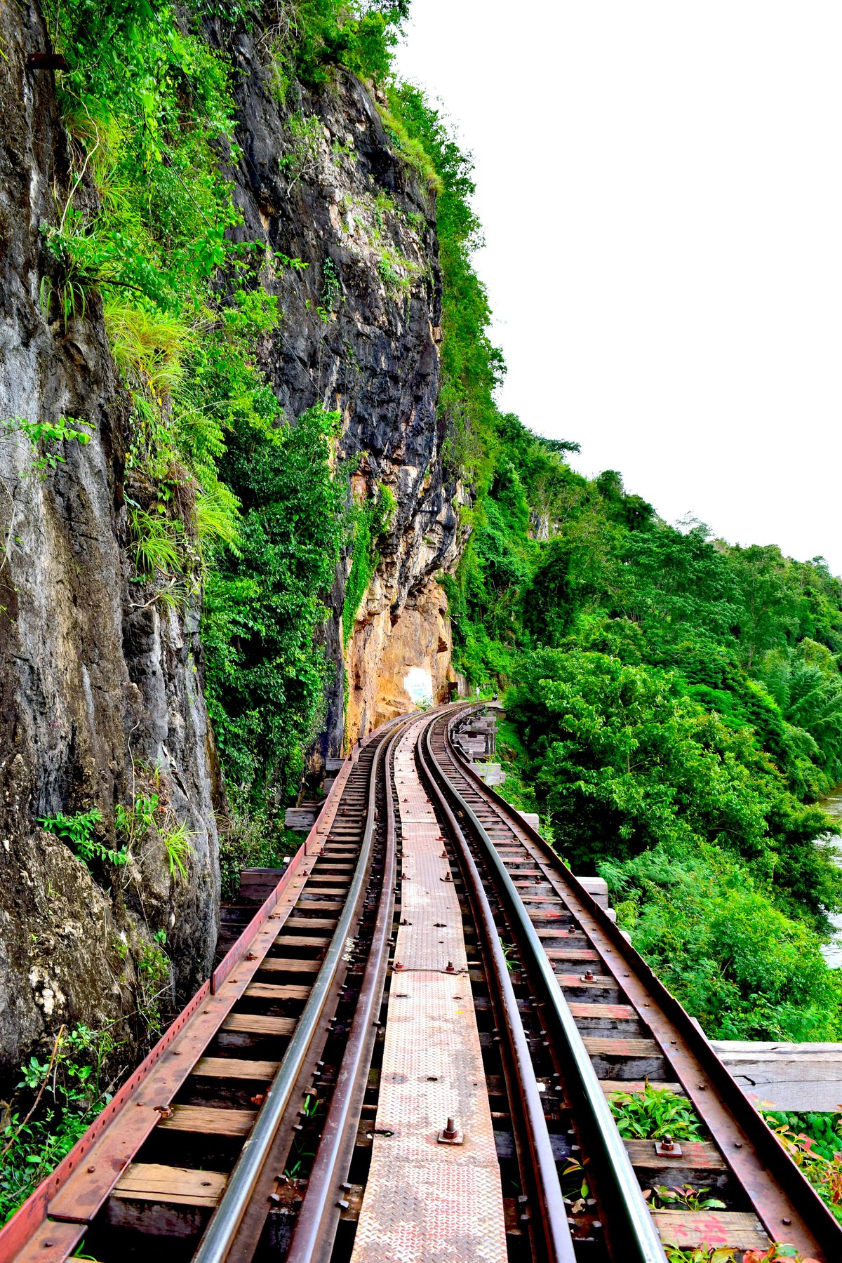 A train on the Death Railway clinging to a cliff above the river
