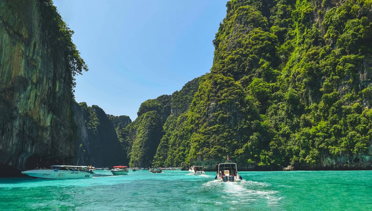 Side-by-side feel — a busy Phuket beach and a quiet Krabi karst bay