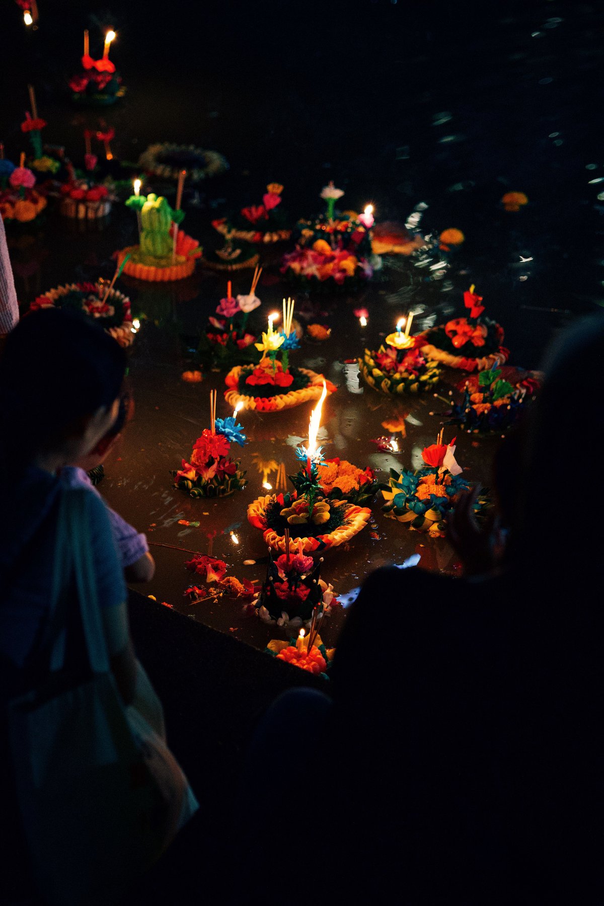 Sky lanterns rising at Yi Peng or floats on water at Loy Krathong