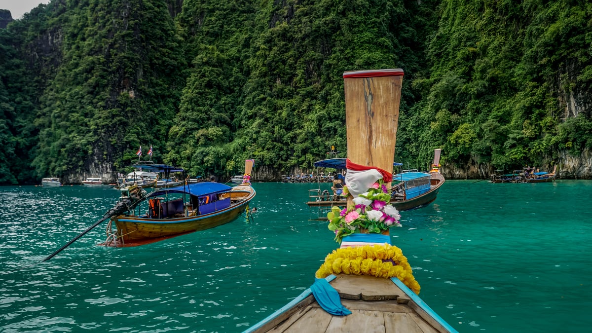 A longtail boat or speedboat at a Thai island pier