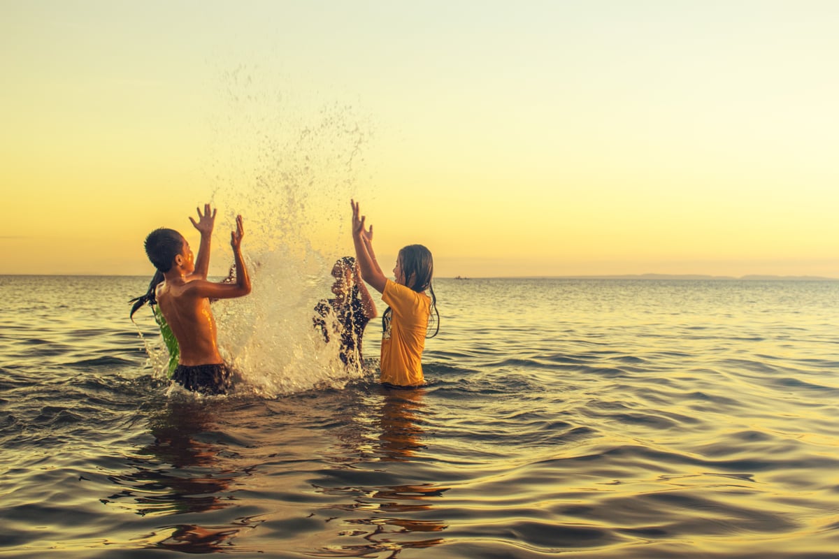 Children playing on a calm, shallow Thai beach