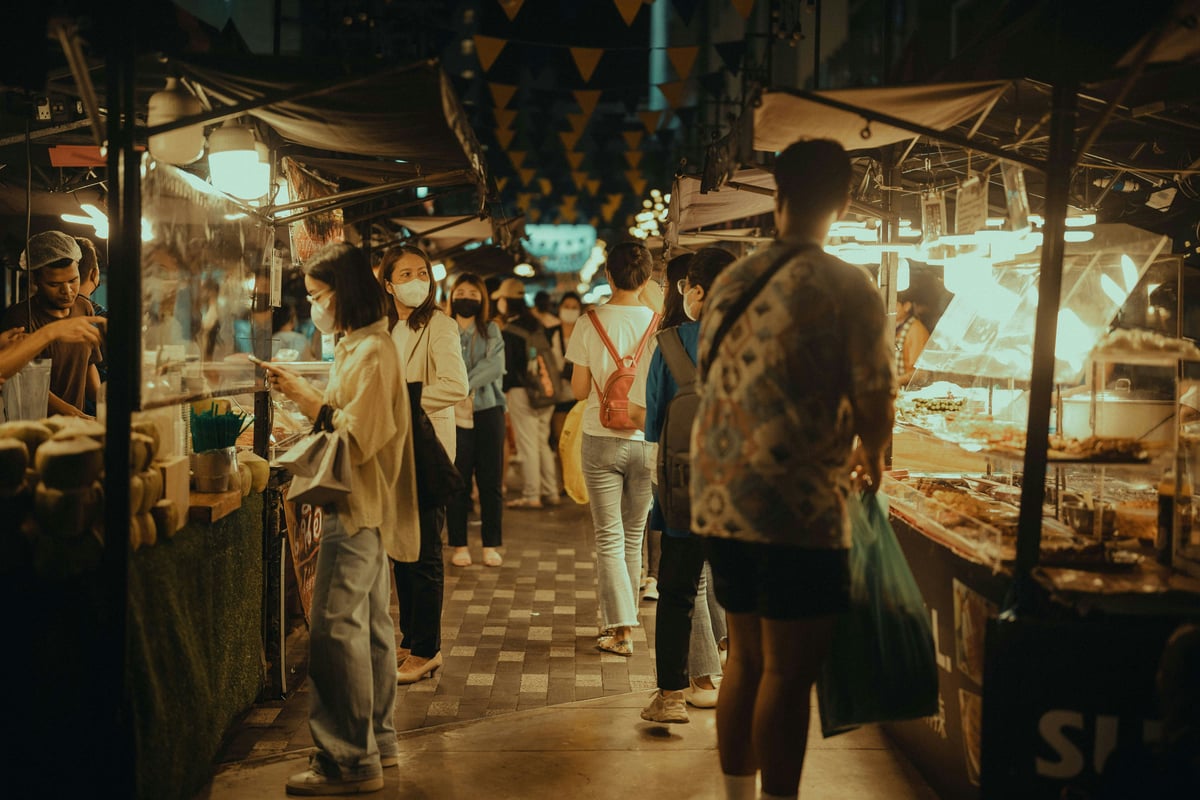 A lively Bangkok street-food scene at night with neon and food carts