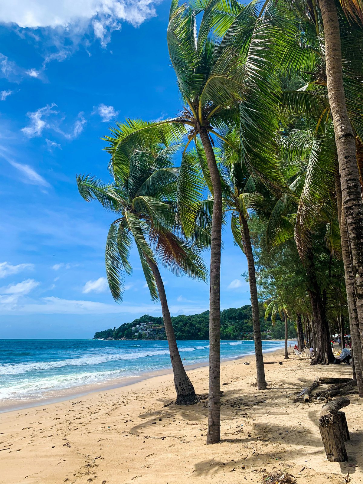 A sweeping Phuket coastline with a beach and headland, daytime