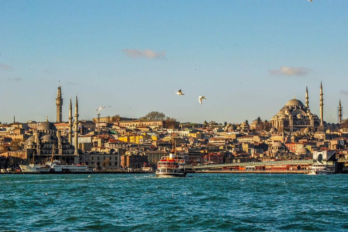 A montage-feel hero of Turkey — Istanbul skyline meeting Cappadocia balloons or the coast, no recognizable faces