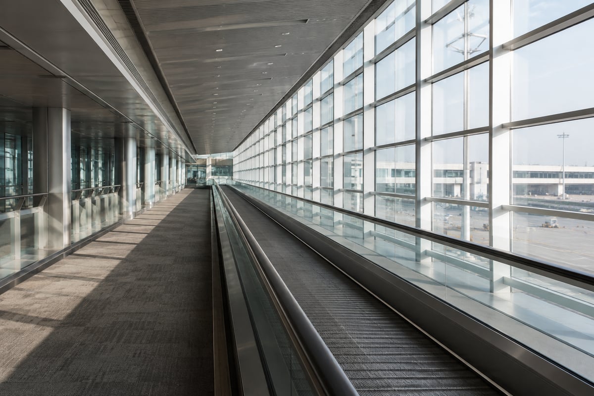 airport moving walkway or transfer corridor, empty, architectural, no faces, no branding