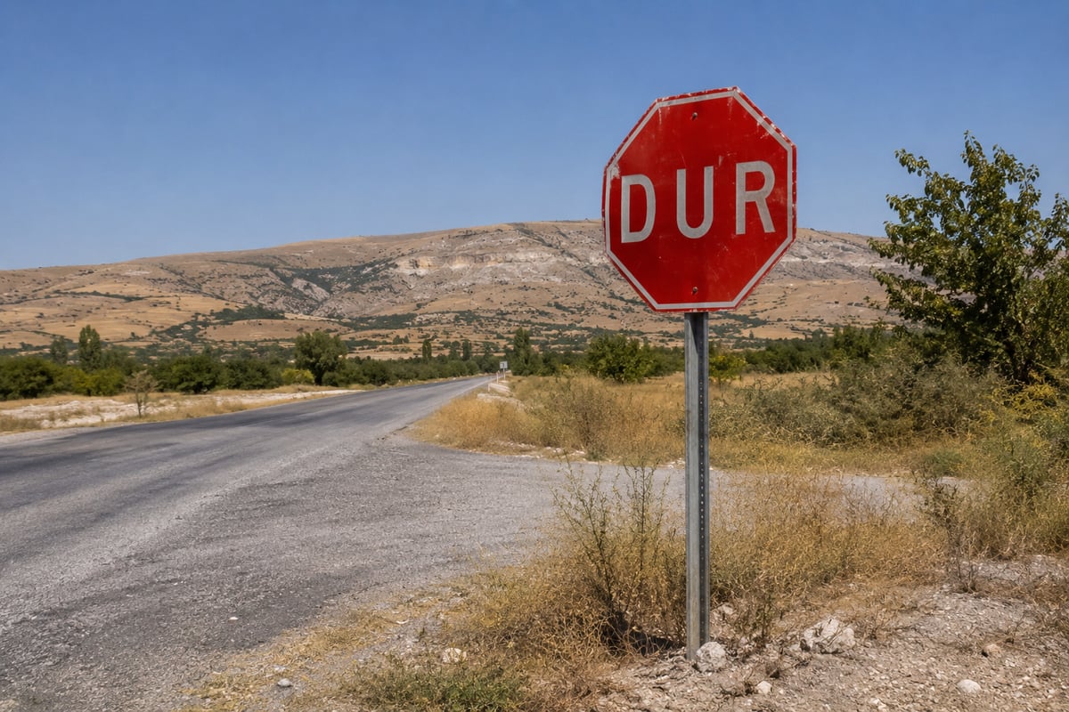 a Turkish road sign or highway marker against open landscape, daylight, no vehicles, no plates