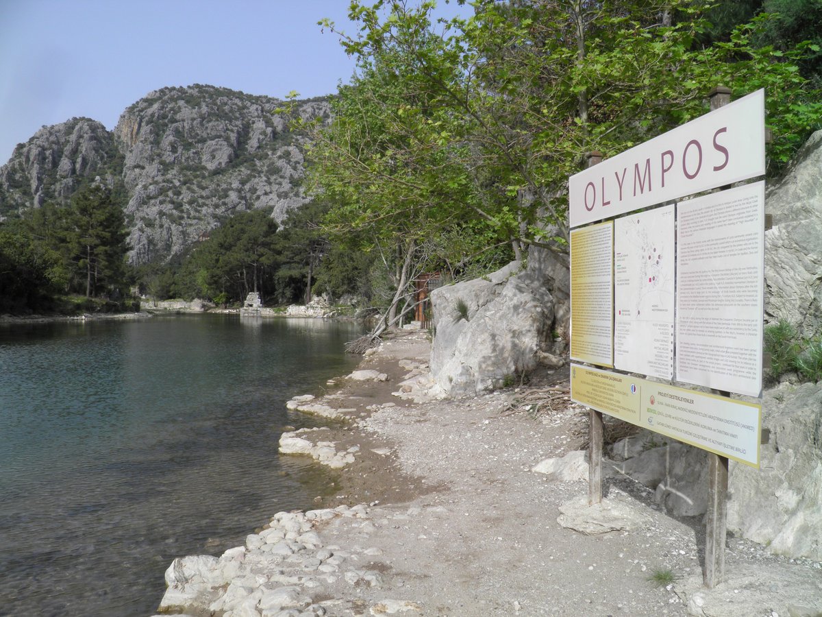 A hiker's view down to a remote turquoise cove from a Lycian Way clifftop path