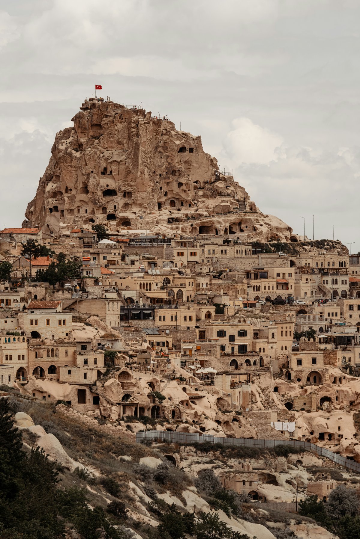 Uchisar Castle rising above cave dwellings with the valley stretching behind