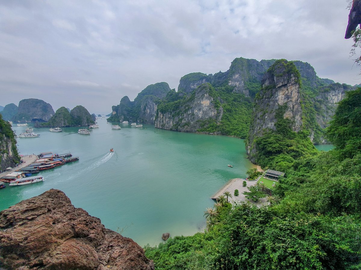 A limestone bay with a boat crossing turquoise water