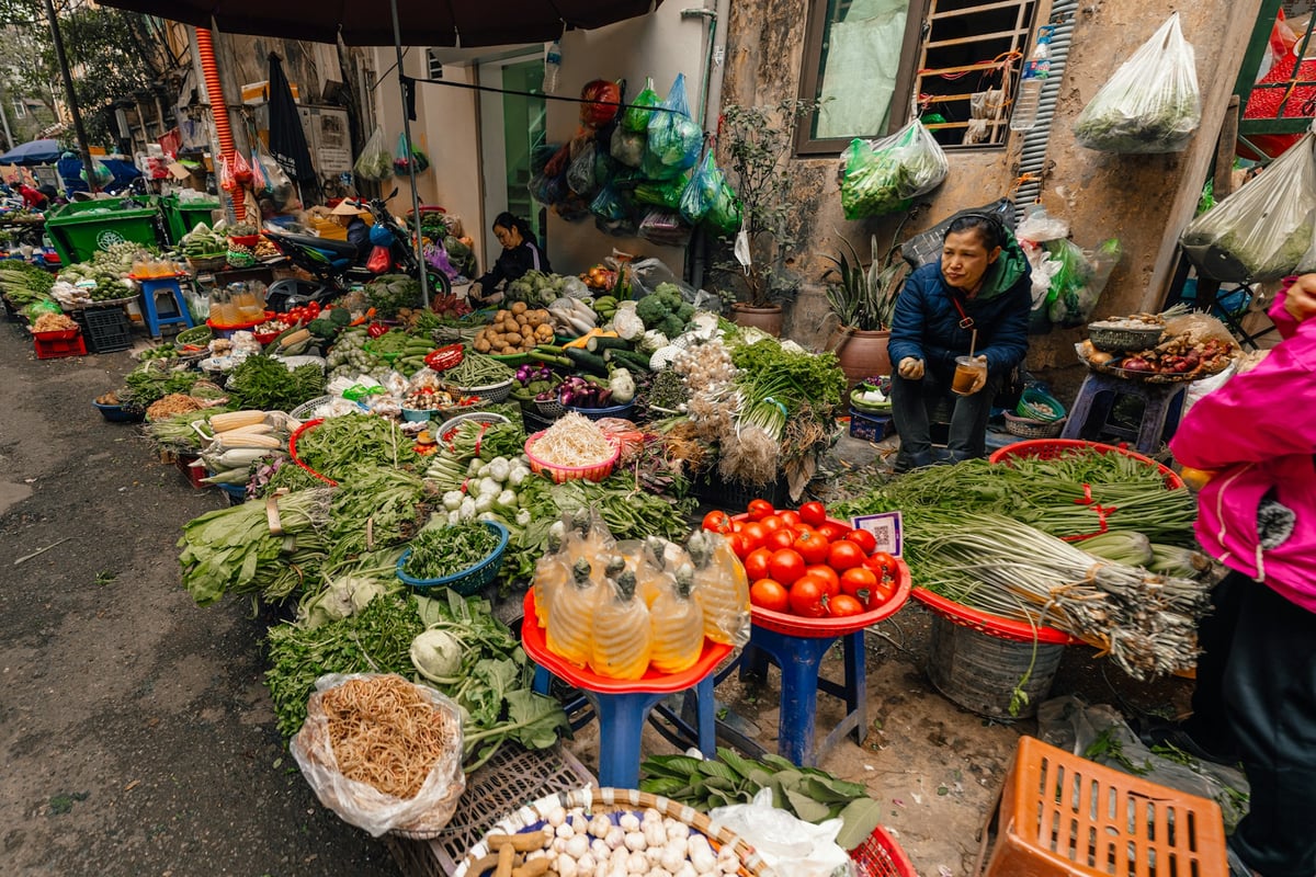 A Vietnamese market stall piled with gourds, chillies and fresh produce