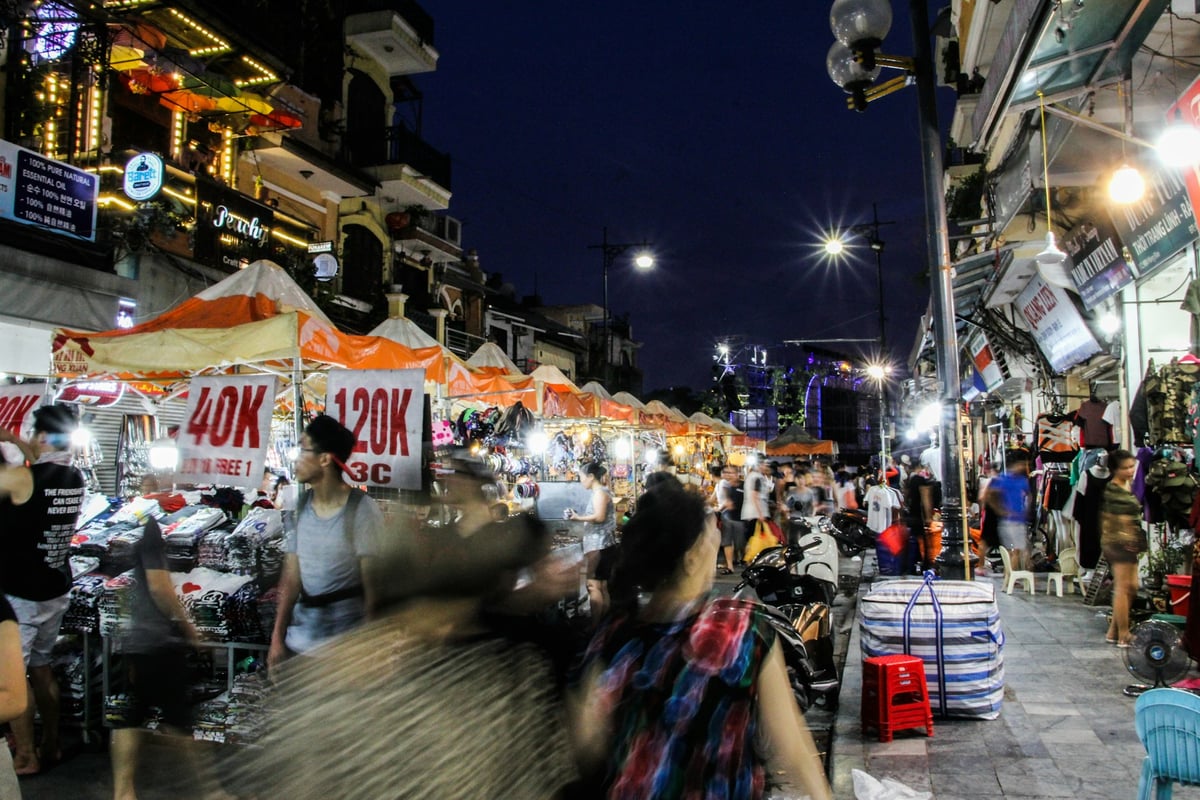 A busy night market street lit with stall lights and crowds