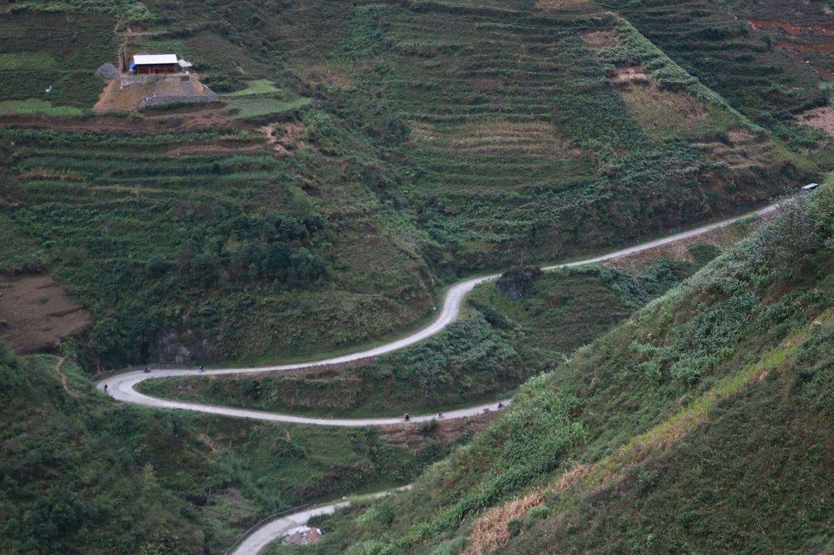 A winding mountain road cut into steep green hillsides in northern Vietnam