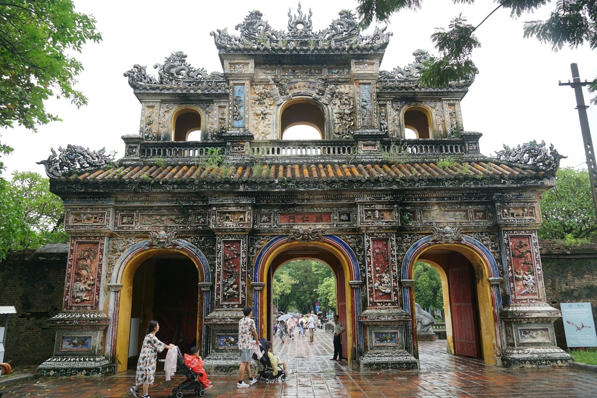 An ornate mosaic-inlaid gate in the Hue Imperial City with visitors passing through