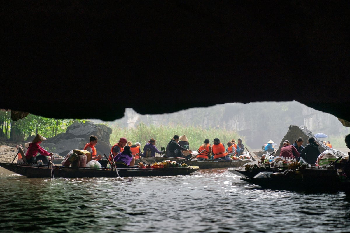 Rowed boats emerging from a water cave at Trang An