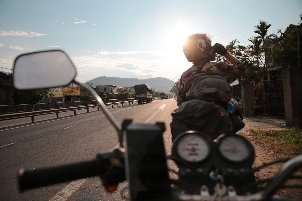 A rider with a backpack on an open road in Vietnam