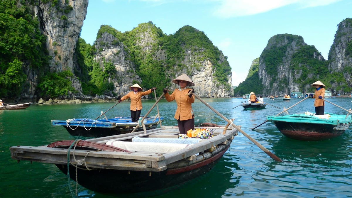 A traveller on the prow of a boat among the karsts of Ha Long Bay