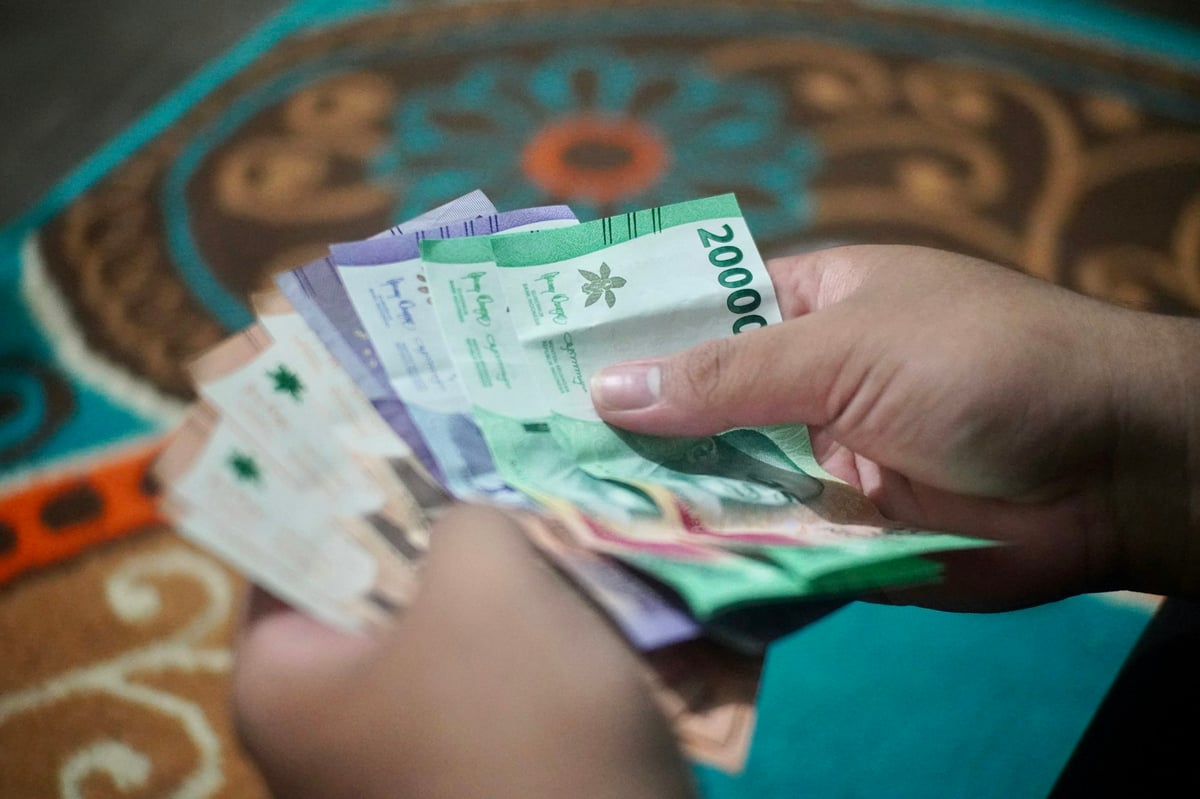 Hands exchanging Vietnamese dong banknotes at a market stall