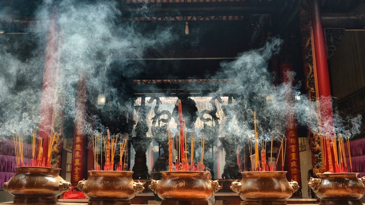 Incense burning in bronze urns inside a Vietnamese temple hall