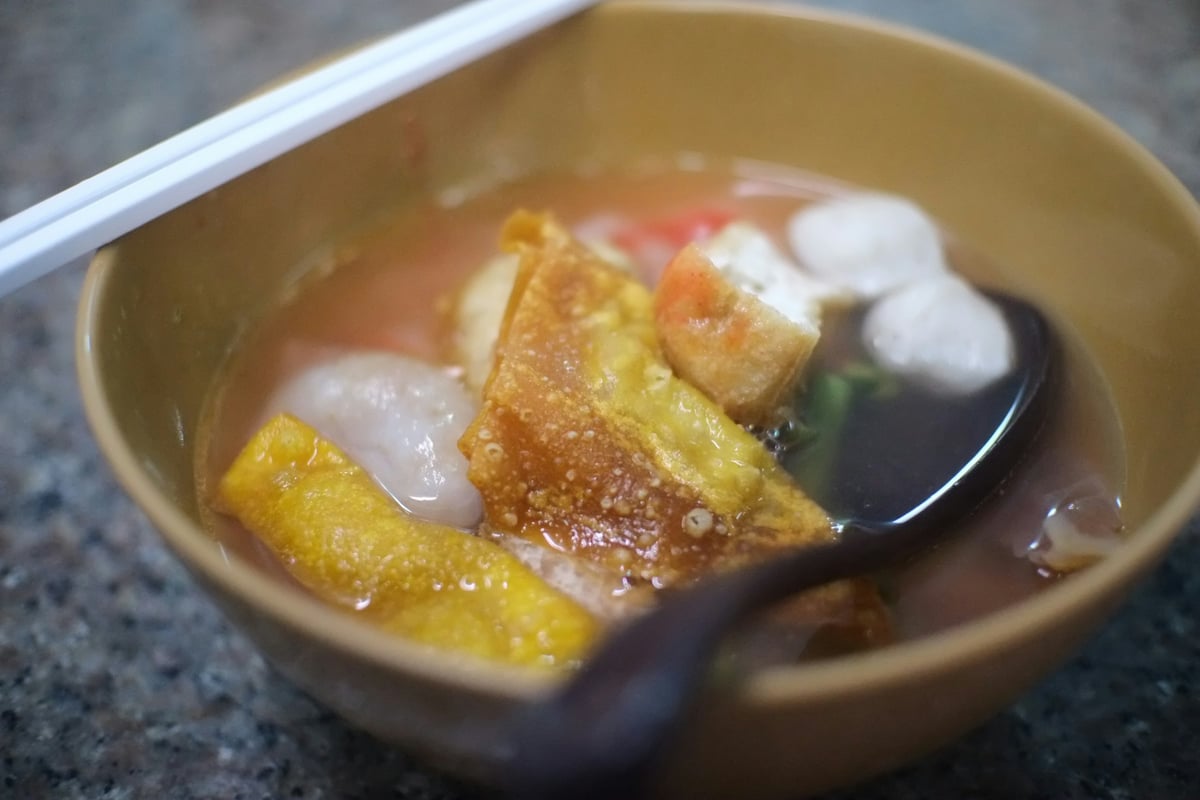 A bowl of sweet soup with jelly, fruit and coconut milk