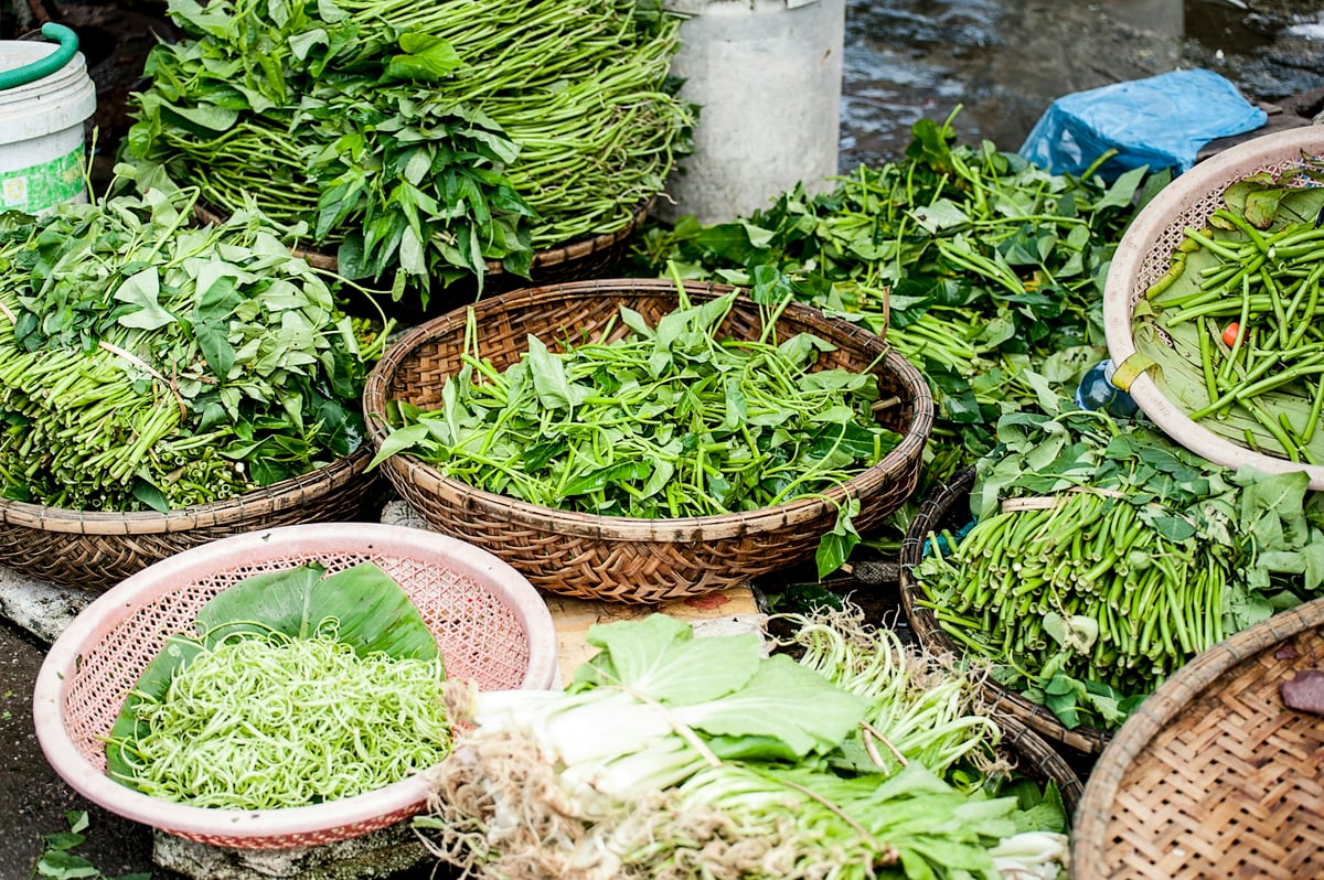 Baskets of fresh herbs and greens at a Vietnamese market
