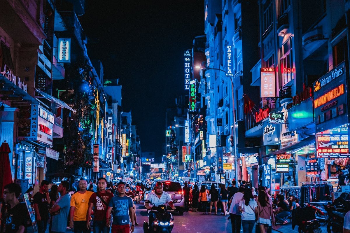 Neon signs along a backpacker bar street in District 1 at night