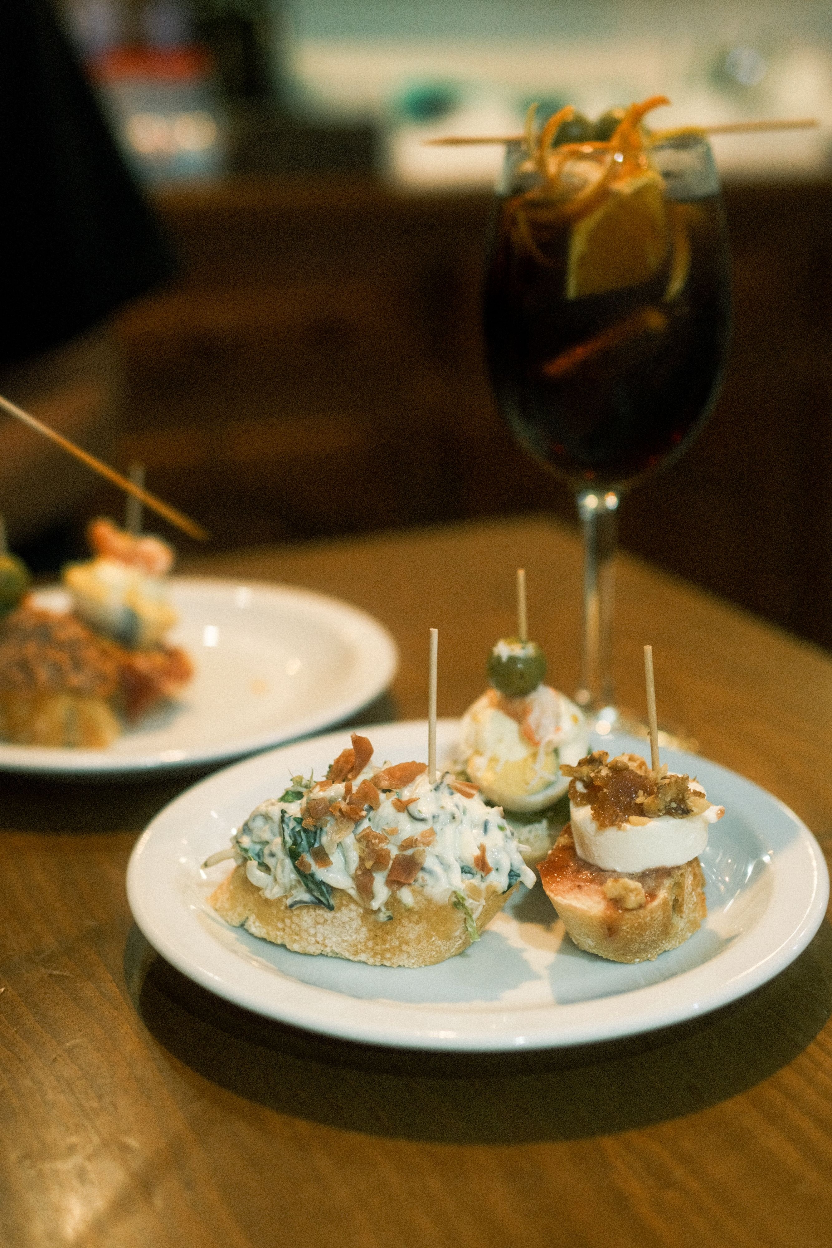 Carrer de Blai pintxos bar counter, colorful pintxos with toothpicks, evening crowd