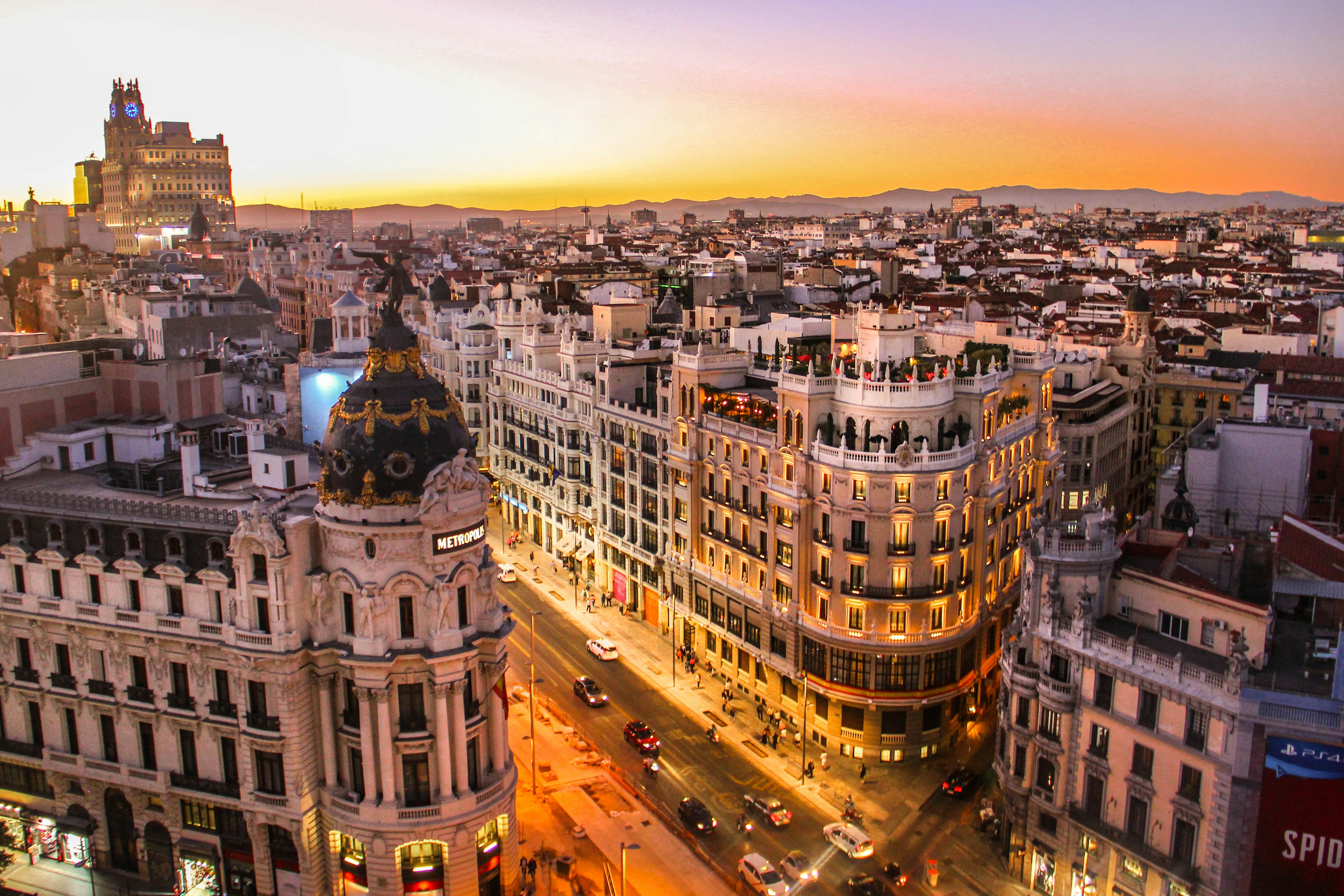 A split or sweeping image suggesting two cities — Barcelona's Sagrada Família and Madrid's grand boulevards