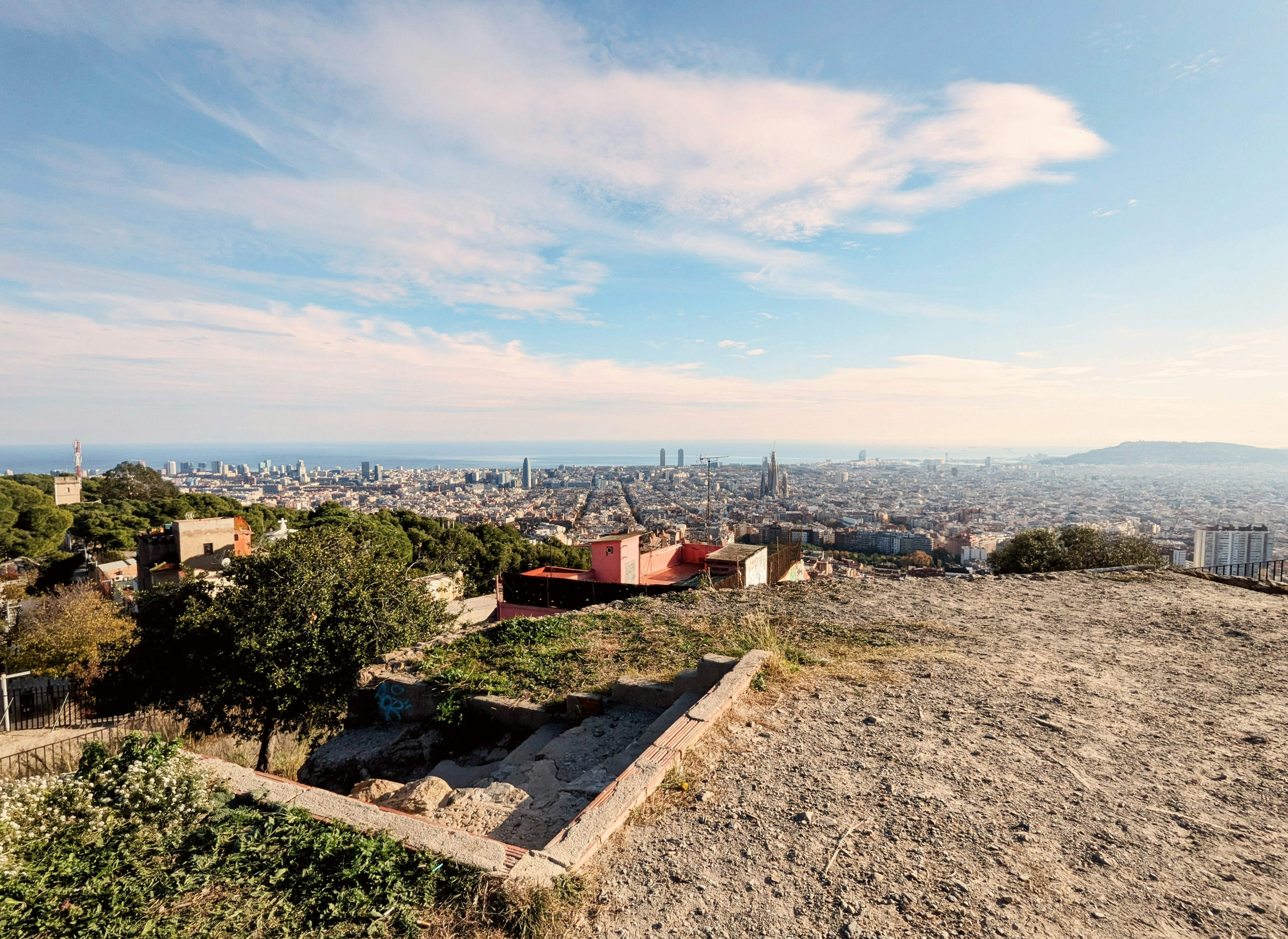 A sweeping Barcelona panorama at golden hour — the city grid, Sagrada Família, and the sea