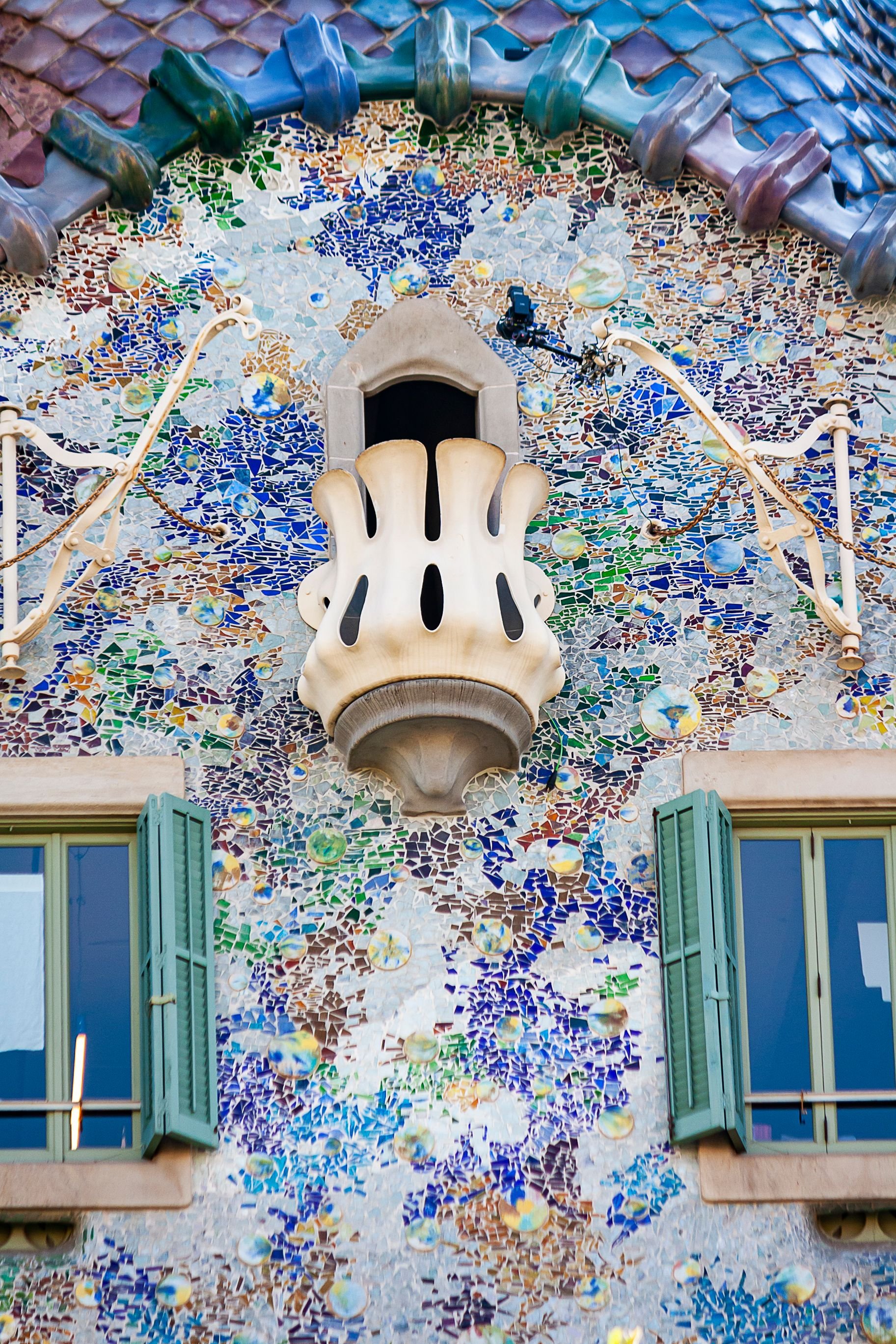 The two houses side by side or a split — Casa Batlló's colorful facade and Casa Milà's stone waves